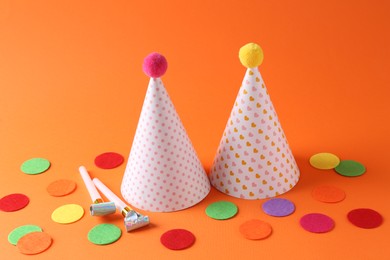 Party hats and other bright decor elements on orange background