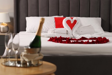 Photo of Honeymoon. Swans made with towels and beautiful rose petals on bed in room