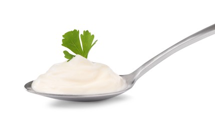 Photo of Delicious sour cream with parsley in spoon on white background