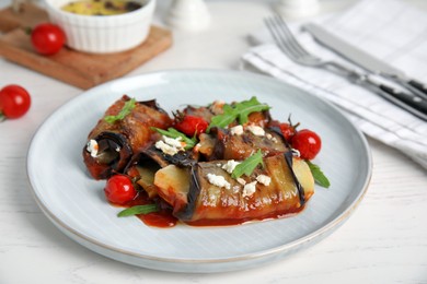 Photo of Delicious baked eggplant rolls served on white wooden table