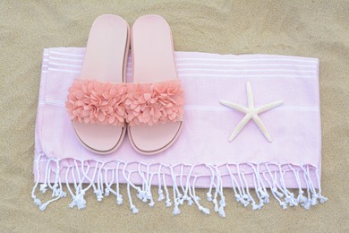 Photo of Blanket with stylish slippers and starfish on sand outdoors, top view. Beach accessories