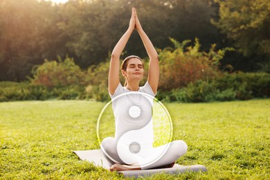 Image of Beautiful woman meditating on mat in park. Yin and yang symbol