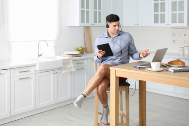 Photo of Businessman in shirt and underwear having videocall on laptop at home