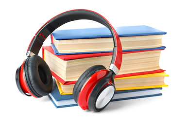 Books and modern headphones isolated on white