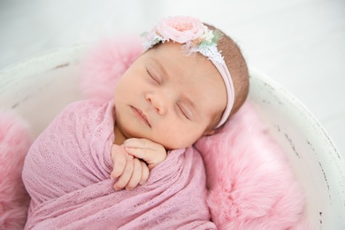 Photo of Adorable newborn girl lying in baby nest, closeup