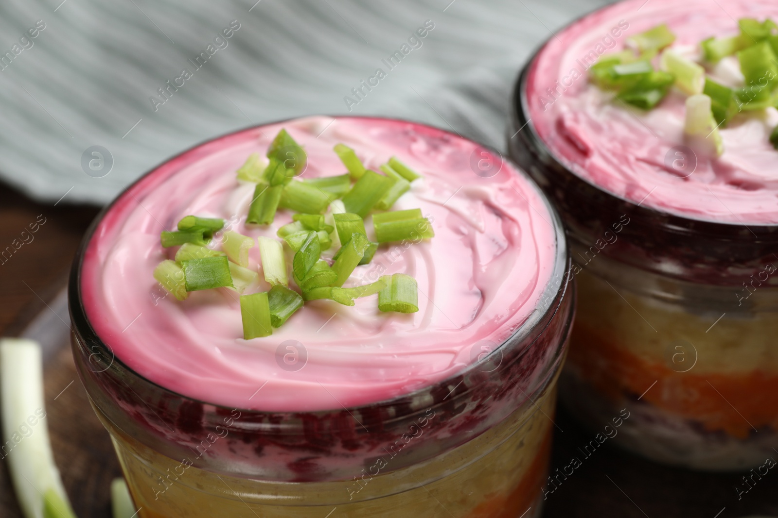 Photo of Glass jars of herring under fur coat, closeup. Traditional Russian salad