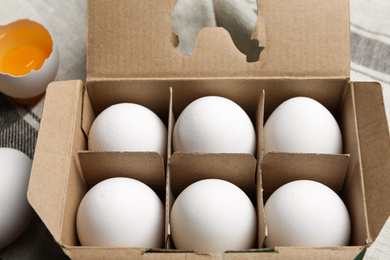 Photo of Fresh raw chicken eggs in box on table, closeup