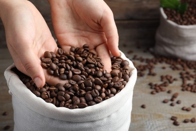 Photo of Woman taking roasted coffee beans from bag, closeup