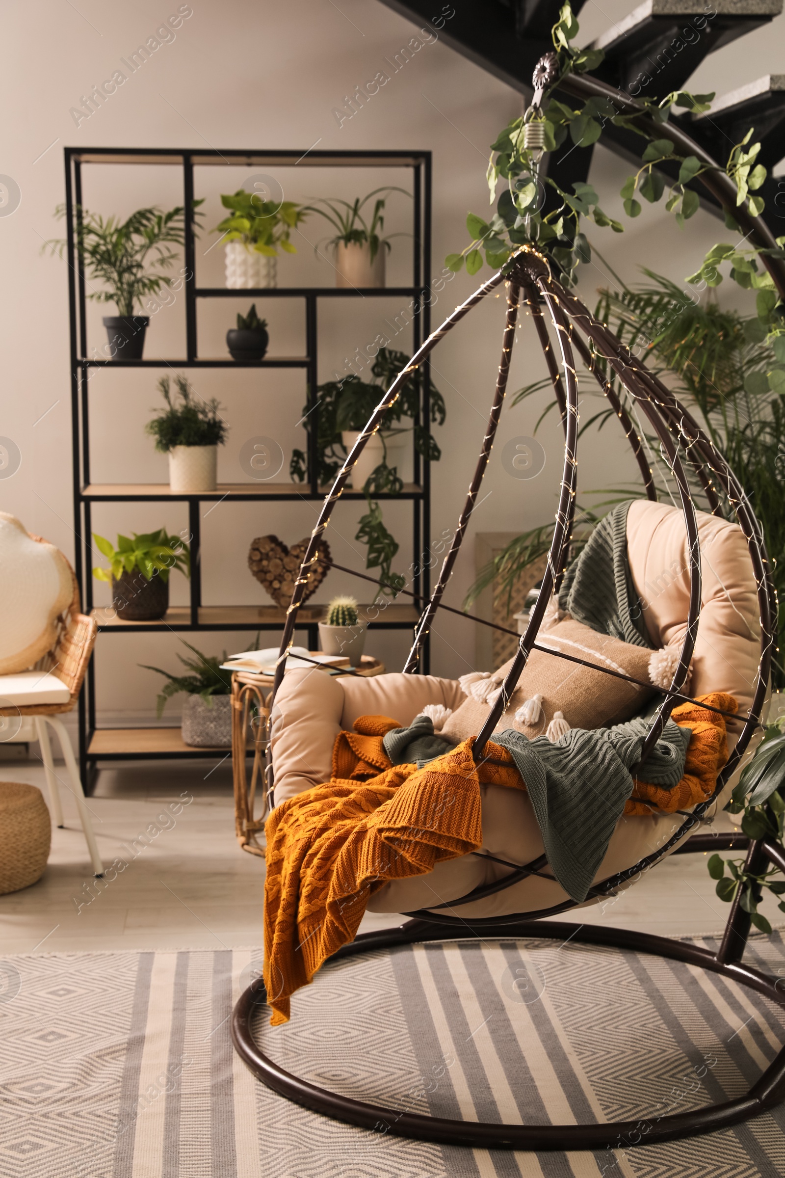 Photo of Indoor terrace interior with hanging chair and green plants