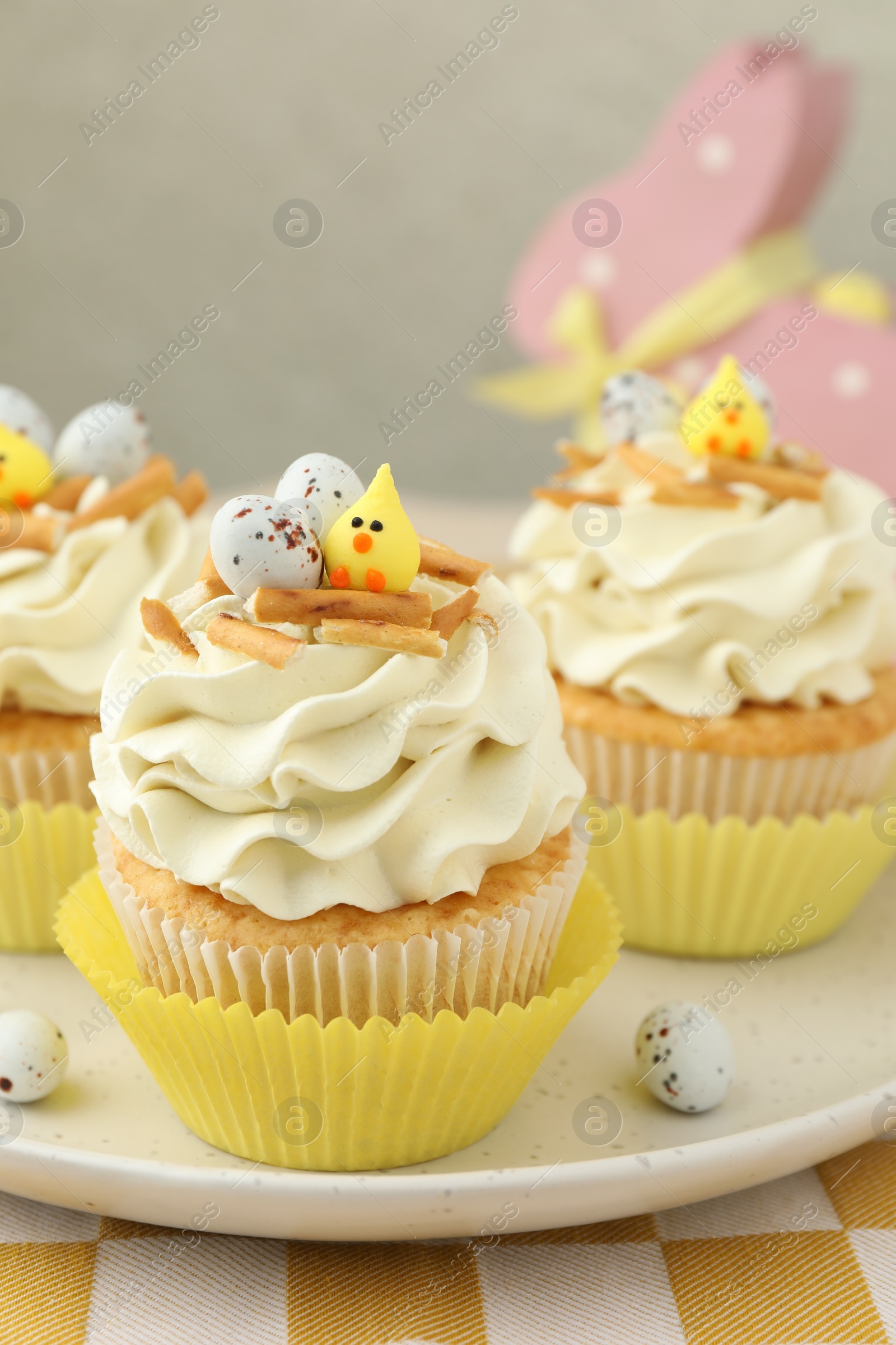 Photo of Tasty Easter cupcakes with vanilla cream on table, closeup