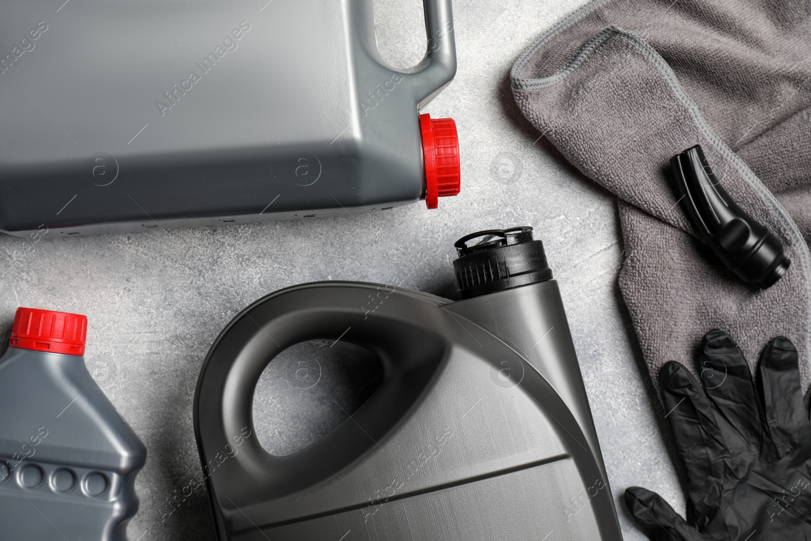 Photo of Car cleaning products, gloves and canister with motor oil on light grey table, flat lay