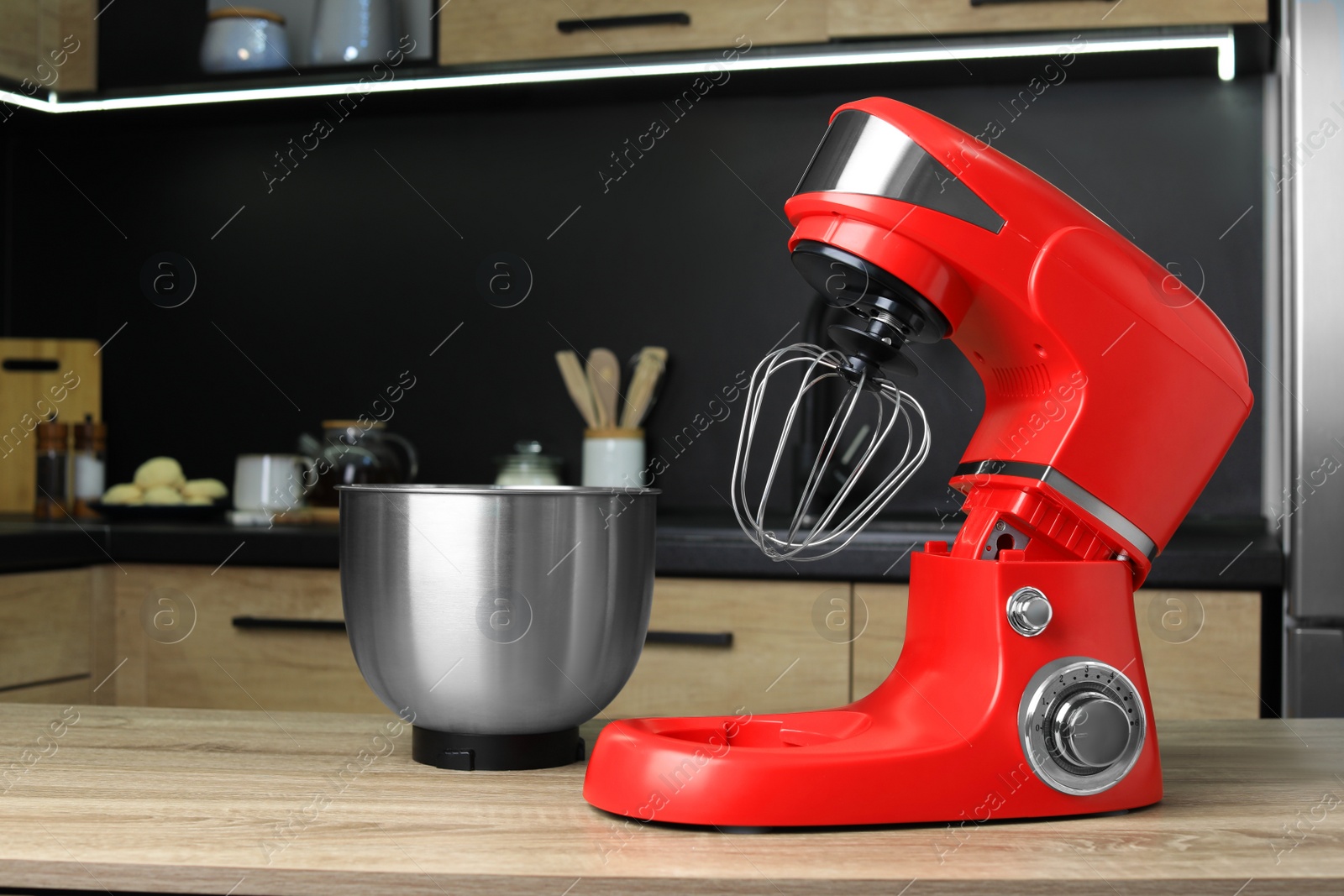 Photo of Modern stand mixer on wooden table in kitchen. Home appliance