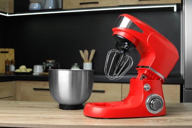 Photo of Modern stand mixer on wooden table in kitchen. Home appliance