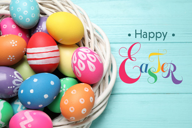 Image of Colorful eggs and text Happy Easter on light blue wooden background, top view