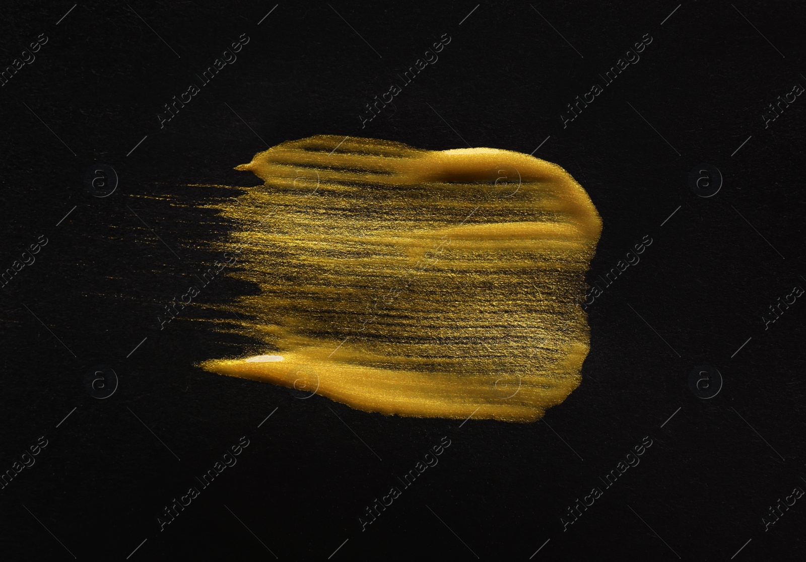 Photo of Golden paint brush strokes on black background