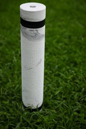 Photo of White karemat or fitness mat on green grass outdoors