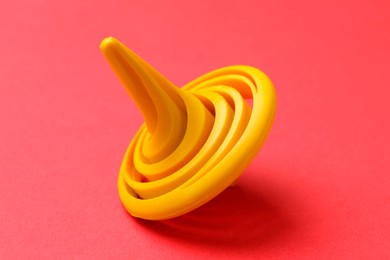 One yellow spinning top on red background, closeup