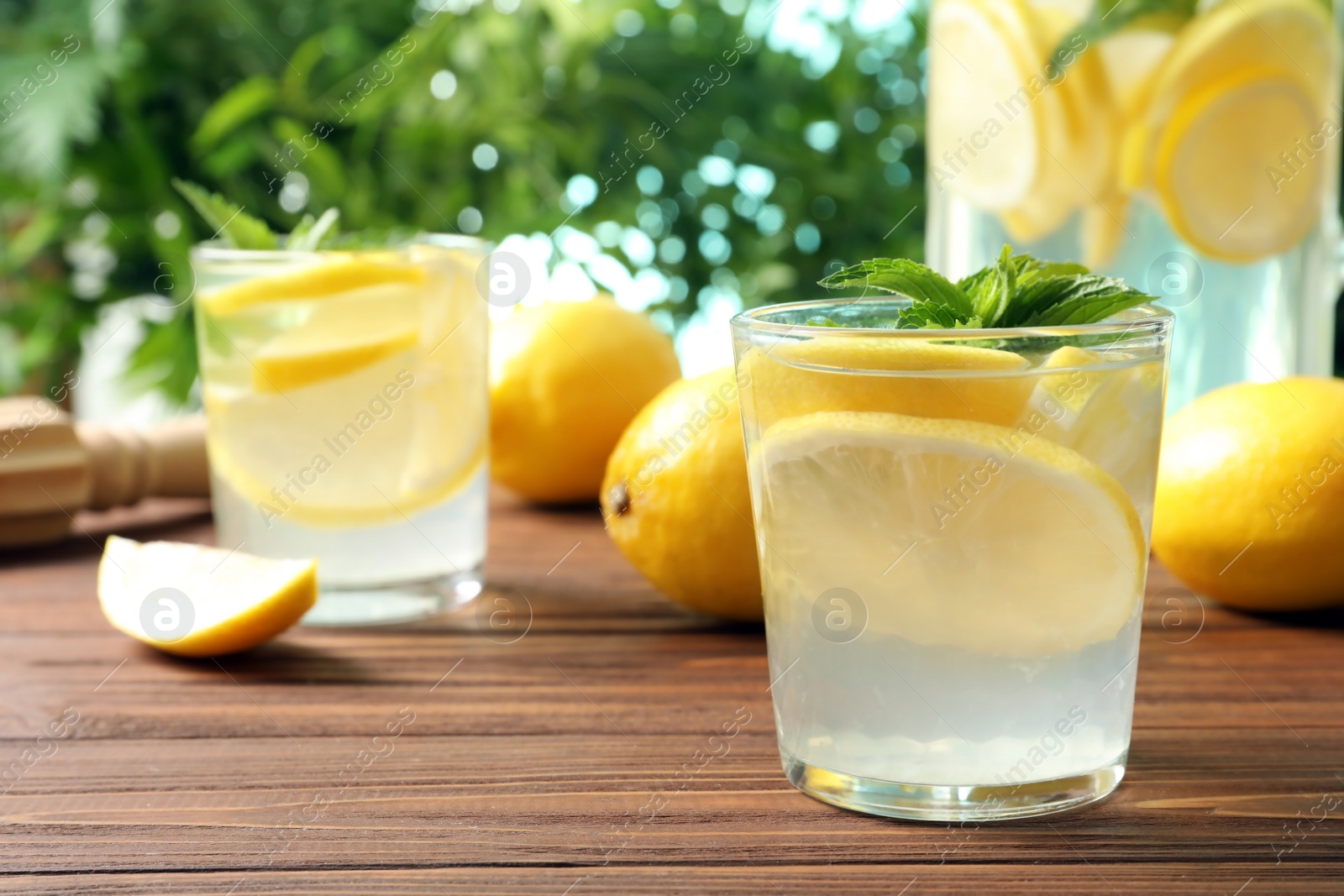 Photo of Natural lemonade with mint in glass on wooden table