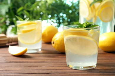 Natural lemonade with mint in glass on wooden table