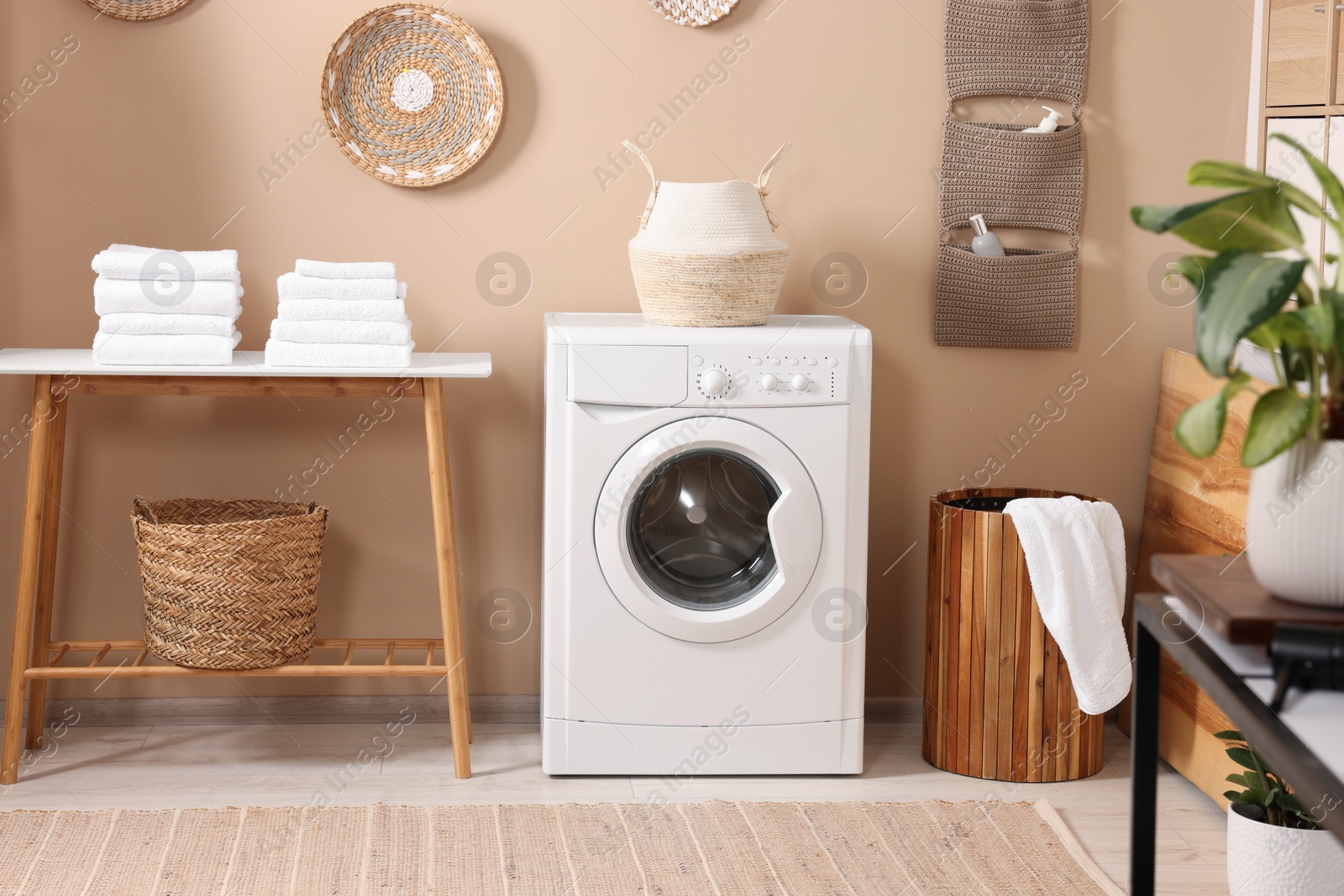 Photo of Stylish laundry room with modern washing machine. Interior design