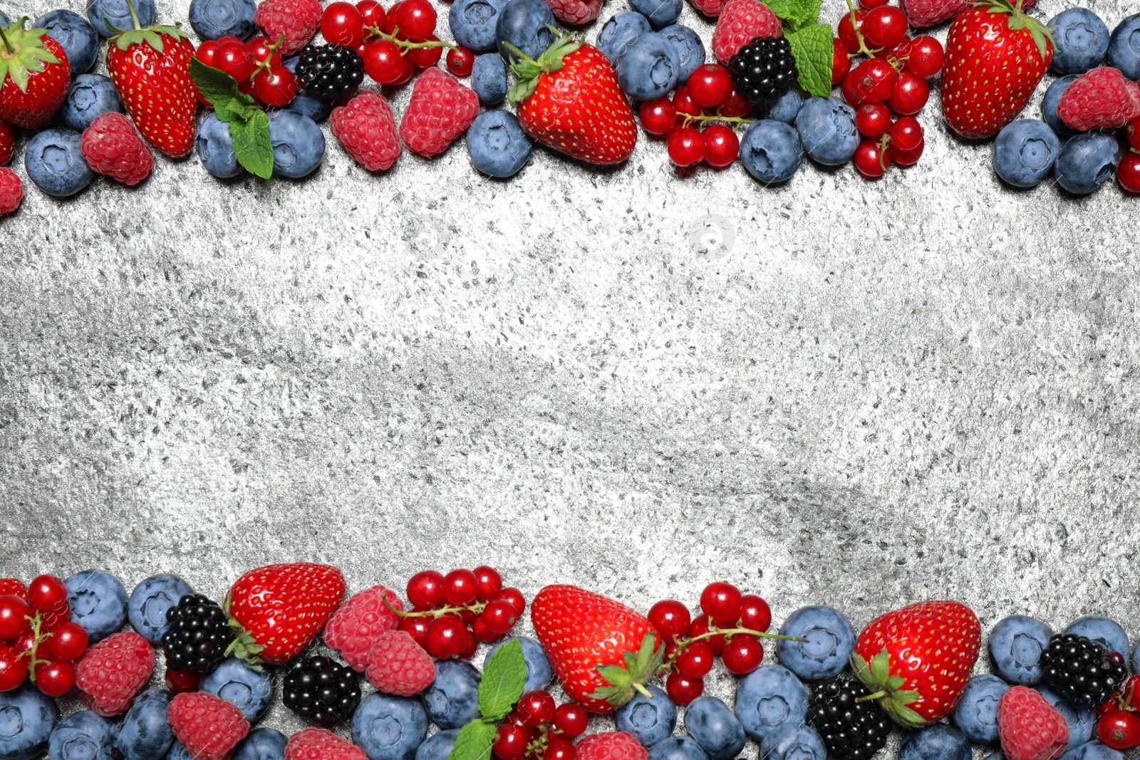 Photo of Different fresh berries on grey background, flat lay. Space for text