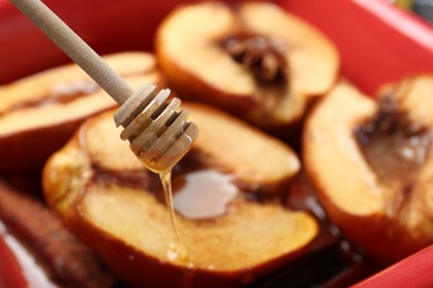 Photo of Pouring tasty honey onto baked quinces in dish, closeup