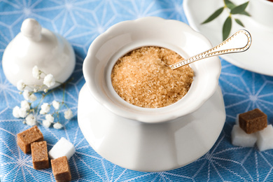 Photo of Ceramic bowl with brown sugar and spoon on table