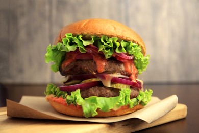 Board with tasty burger on wooden table, closeup