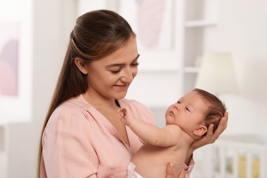 Mother holding her cute newborn baby at home