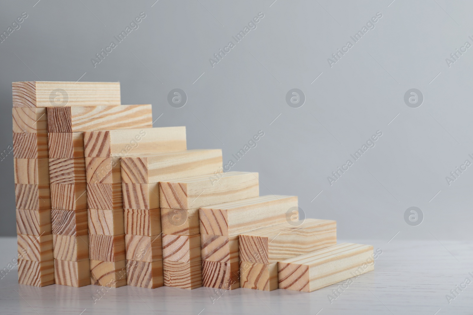 Photo of Steps made with wooden blocks on light background, space for text. Career ladder