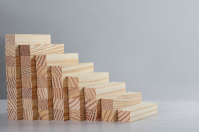 Photo of Steps made with wooden blocks on light background, space for text. Career ladder