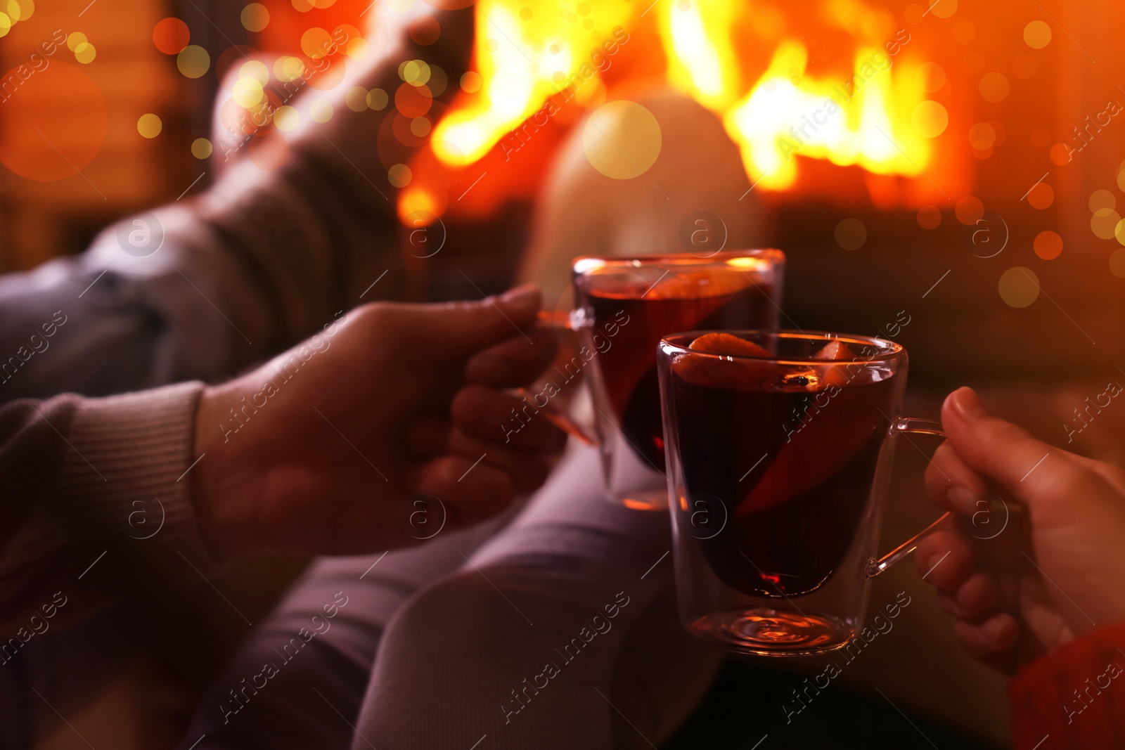 Image of Couple with mulled wine near fireplace indoors, closeup. Winter vacation