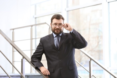 Photo of Portrait of confident mature man in elegant suit on stairs