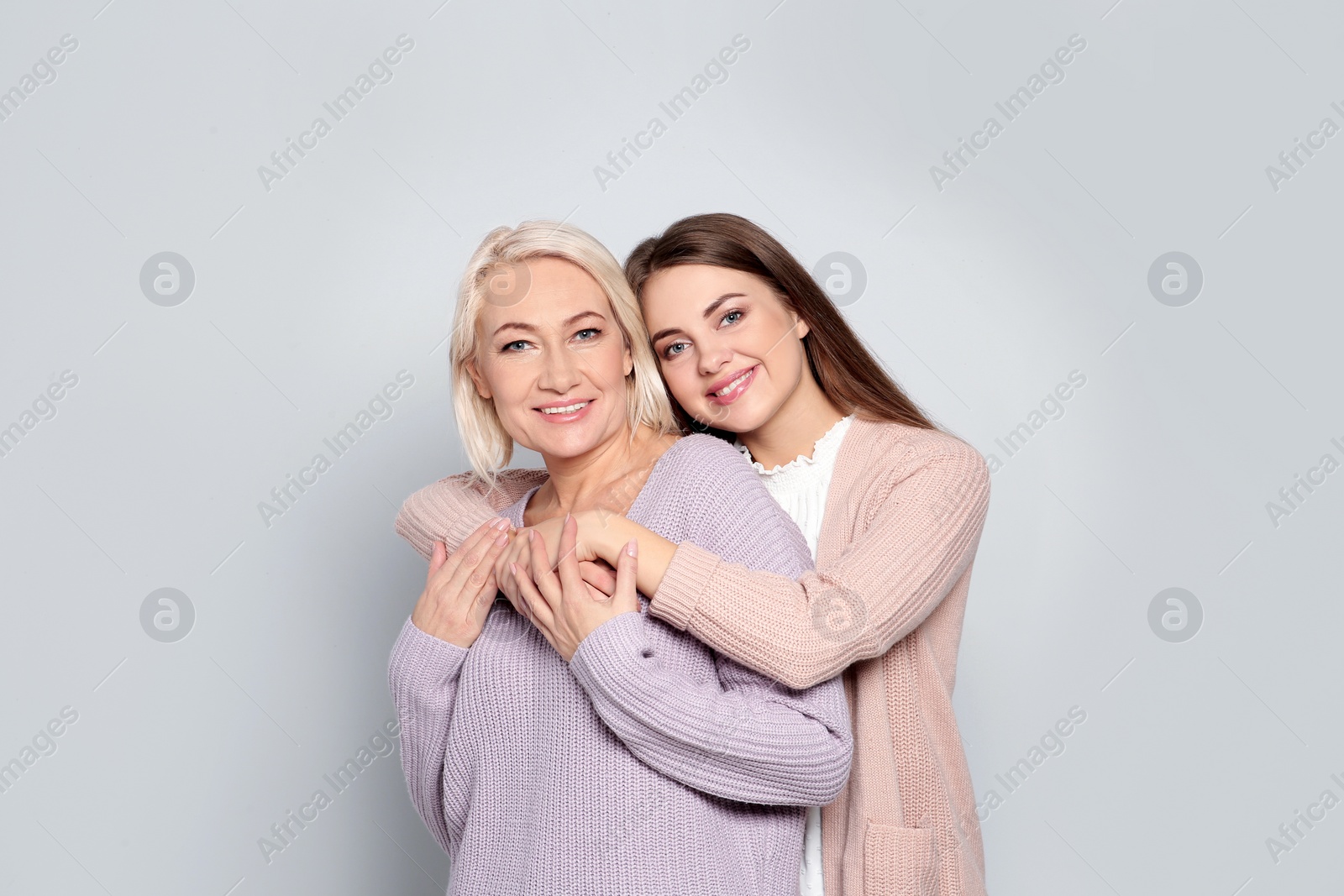 Photo of Portrait of mature woman and her daughter on color background