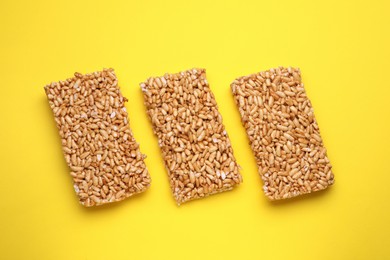 Puffed rice bars (kozinaki) on yellow background, flat lay