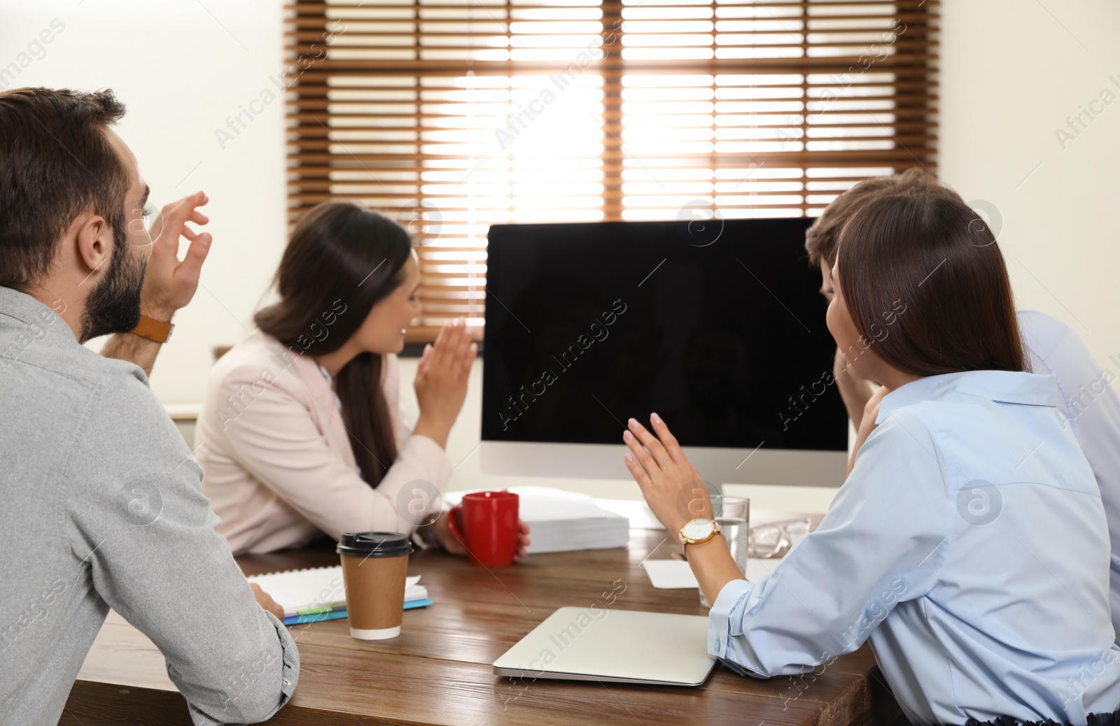 Photo of Group of colleagues using video chat on computer in office. Space for text