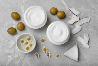 Photo of Body cream with ingredients on light grey marble table, flat lay