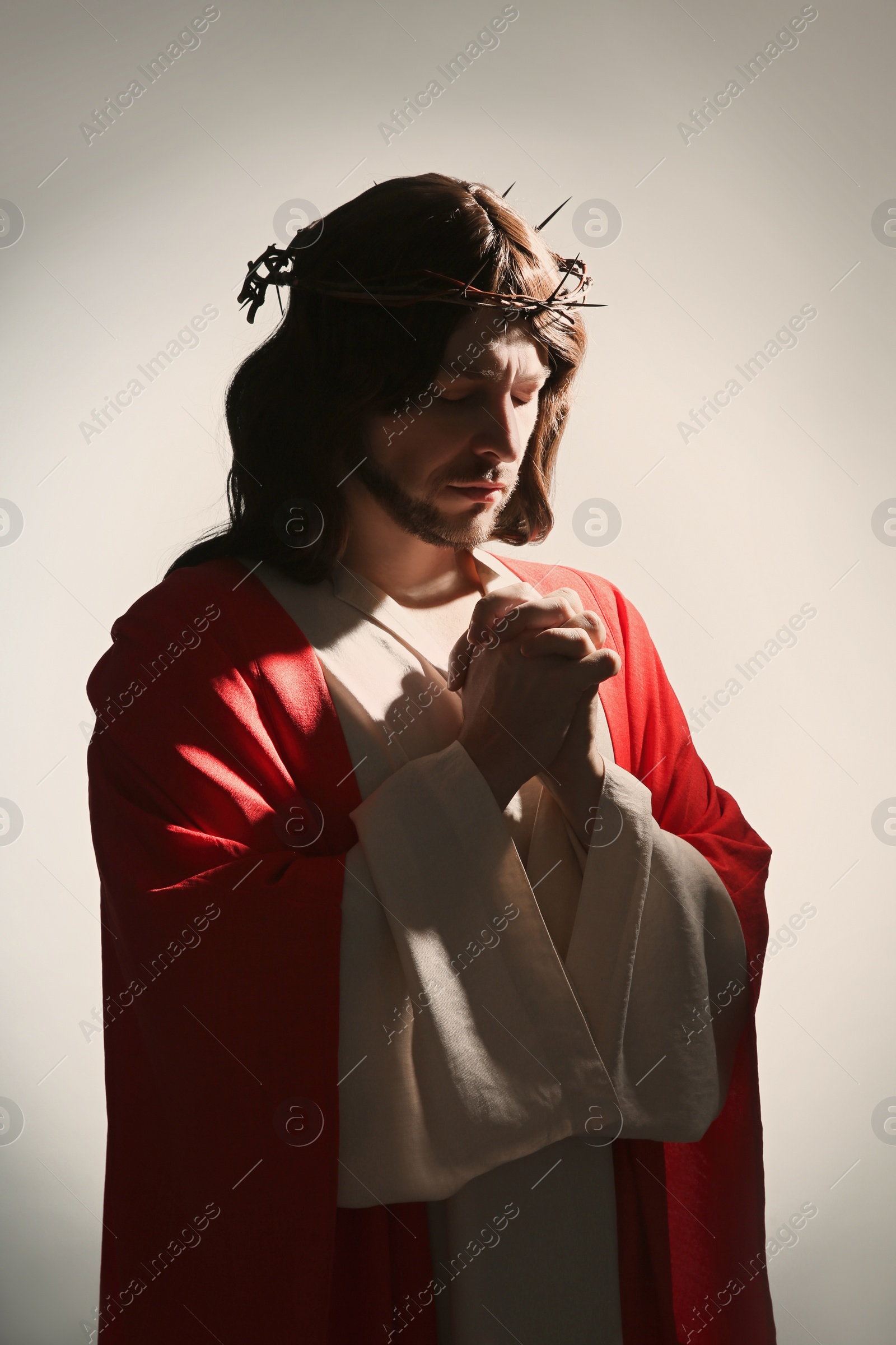 Photo of Jesus Christ with crown of thorns praying on white background