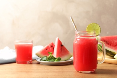 Photo of Summer watermelon drink in mason jar and sliced fruit on table