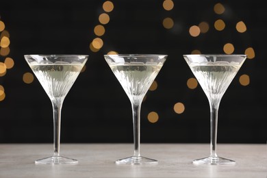 Martini glasses of refreshing cocktails on light grey table