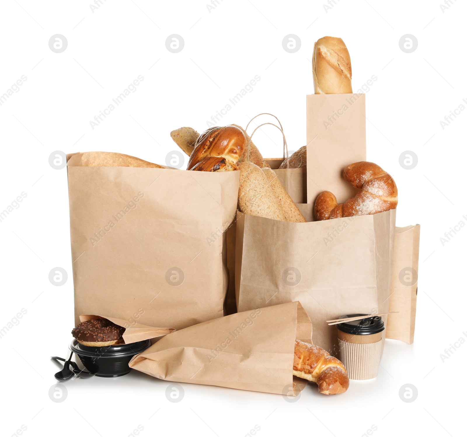 Photo of Different fresh bakery products in paper bags on white background