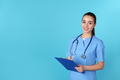 Young medical student with clipboard on color background. Space for text