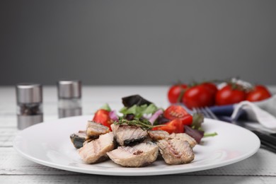 Delicious canned mackerel chunks served on white wooden table, closeup