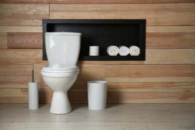 Photo of Toilet bowl in modern restroom interior. Space for text