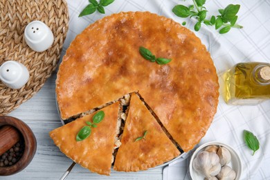 Photo of Delicious meat pie served on white wooden table, flat lay