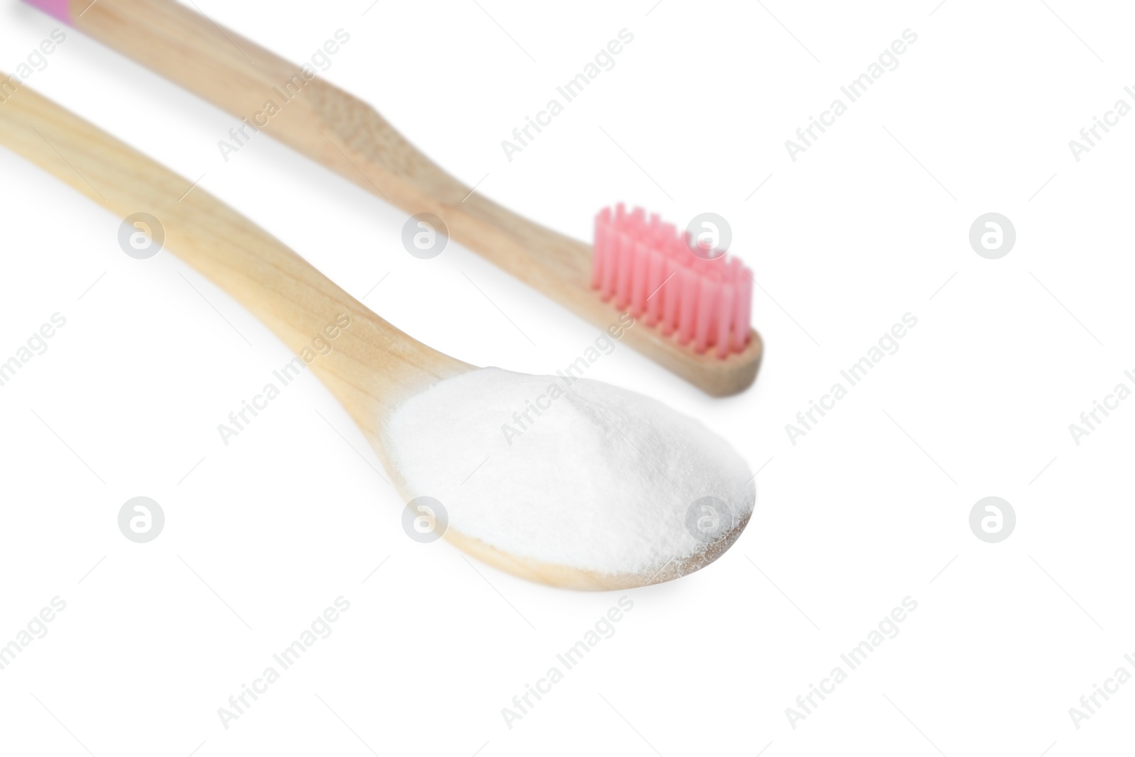 Photo of Bamboo toothbrush and wooden spoon with baking soda on white background