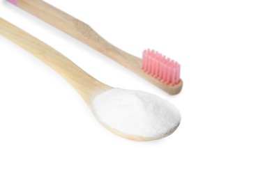 Bamboo toothbrush and wooden spoon with baking soda on white background