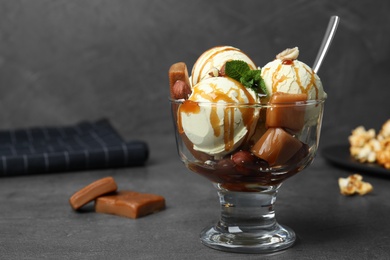 Photo of Delicious ice cream with caramel and sauce served on table. Space for text