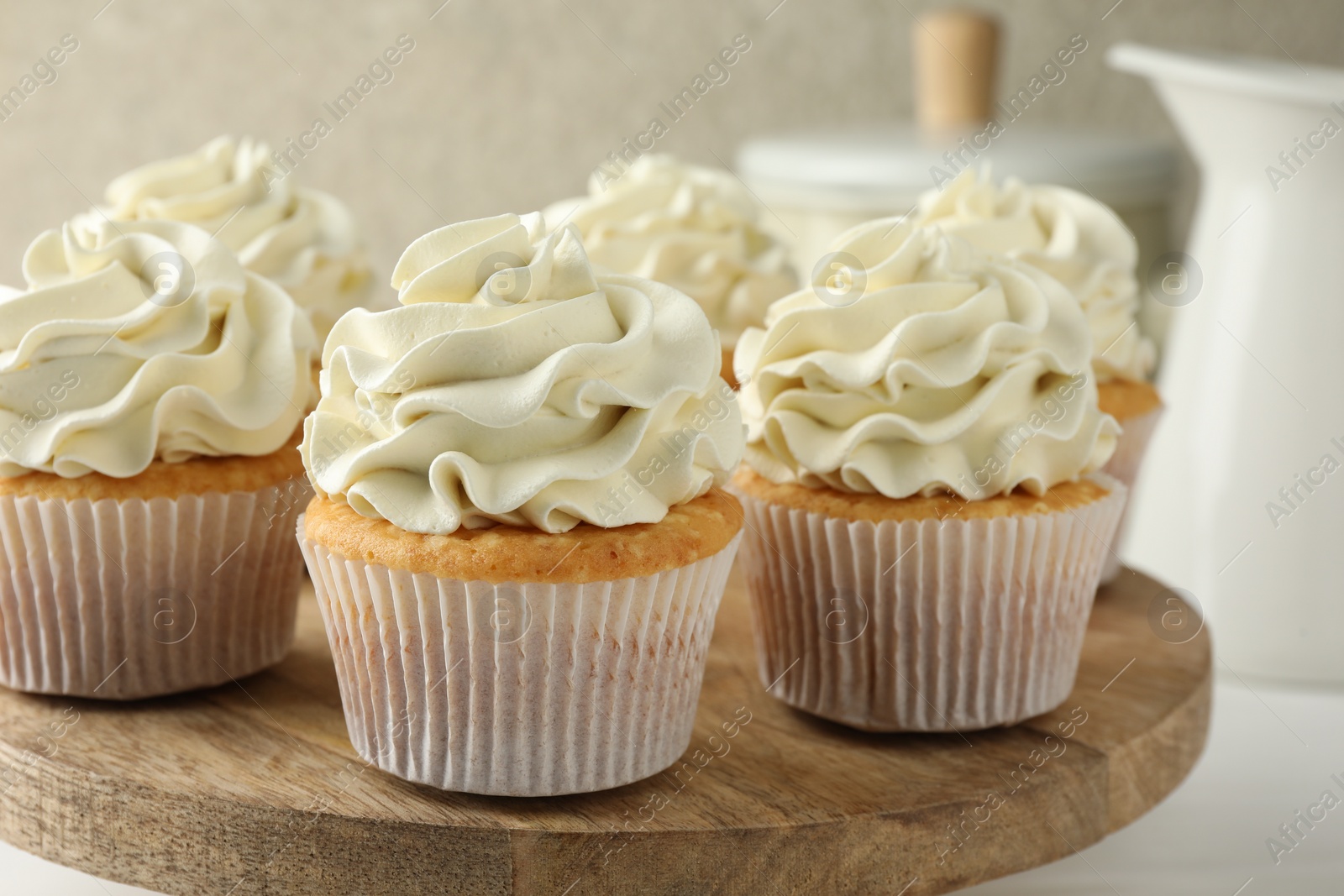 Photo of Tasty vanilla cupcakes with cream on white table, closeup