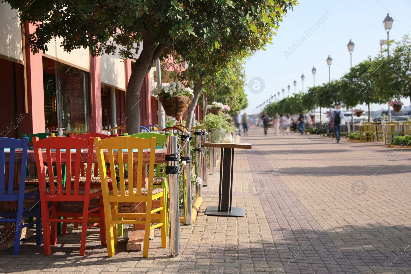 Photo of Beautiful view of outdoor cafe with colorful wooden chairs